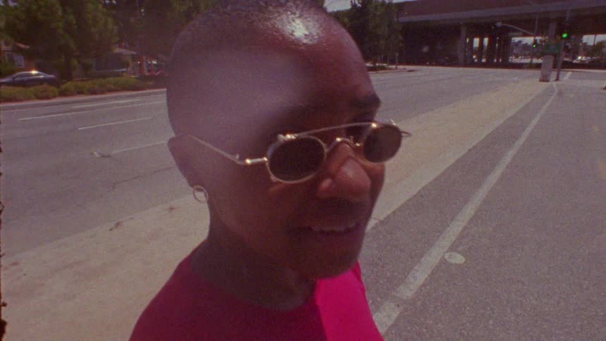 Woman wearing sunglasses standing on the highway near a bridge