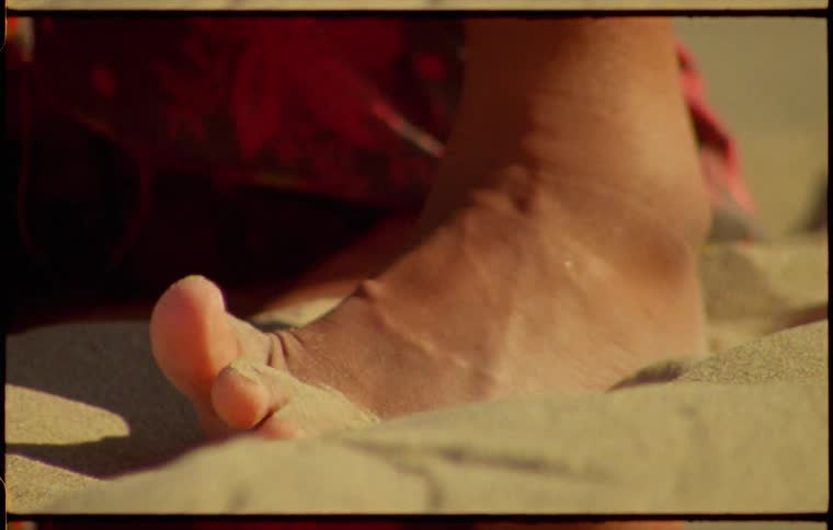 A persons feet rubbing on sand