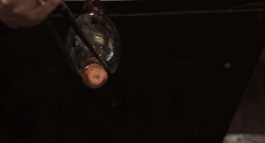 A glass is being spun with a metal tool