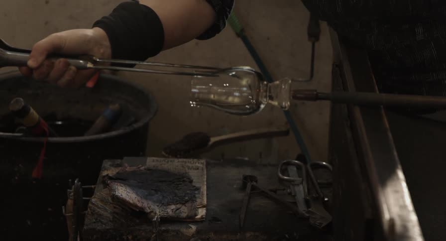A glass is being formed with tools