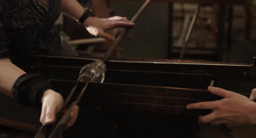 Two people are working on creating a glass