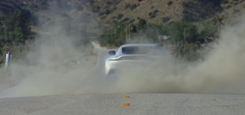 A car is driving on a road in a rural area