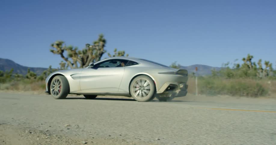 A person that is driving in a car on a dirt road