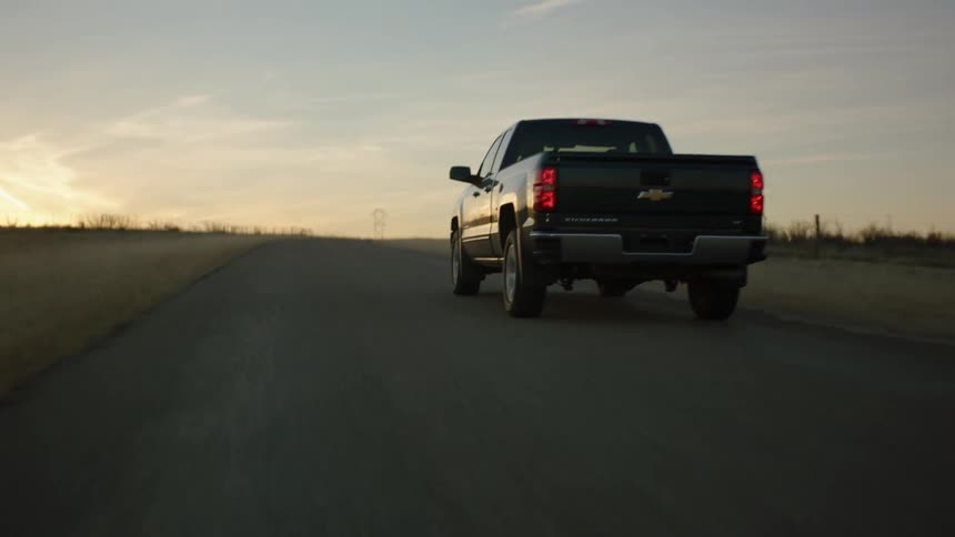 A truck is driving on the road at sunrise