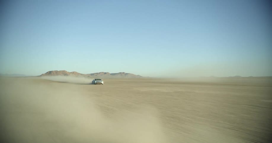 Sports car leaving a dust trail while driving on the desert