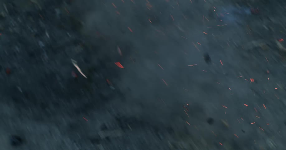 Aerial view of a small fire burning on the ground and sparks flying