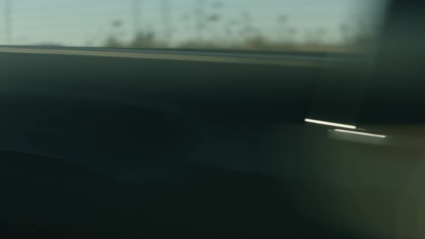 Black pickup truck driving on a road through the desert