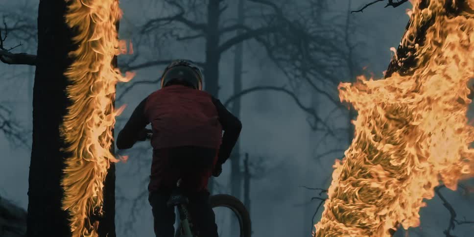 Cyclist jumping through two burning trees.