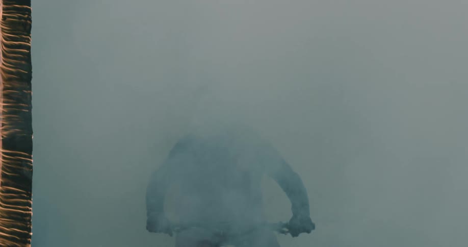 A person wearing a helmet rides a bike through a smoke wall.