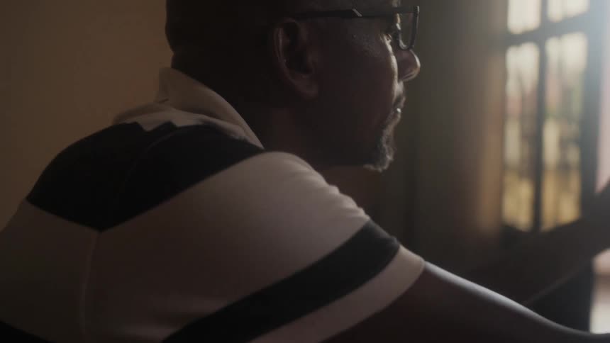 A man closes his folder and uses the laptop