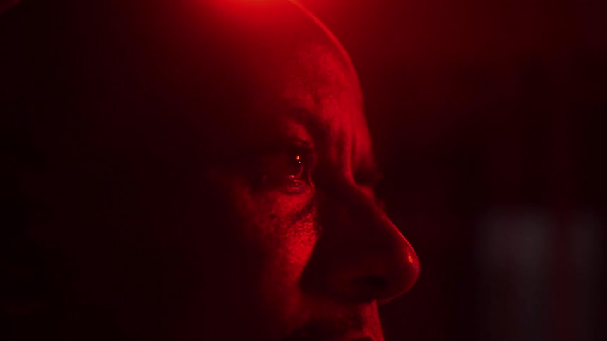 A red light reflecting on a mans face