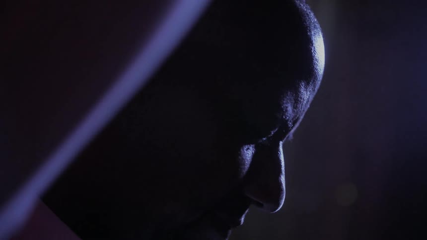 A man rubbing his head up close