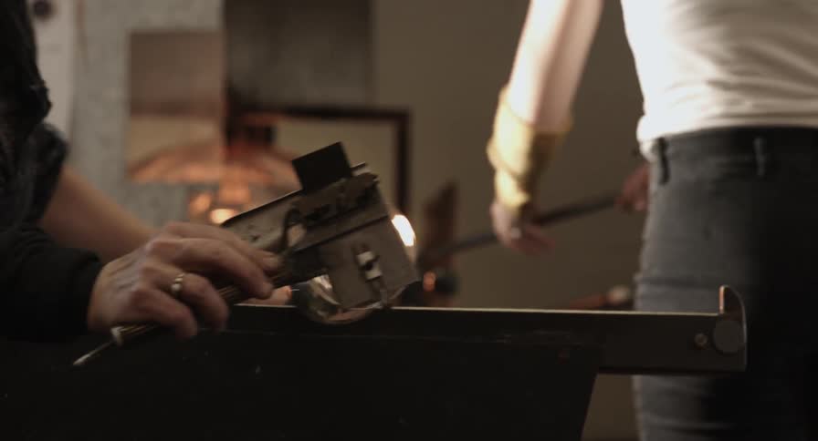 A glass is being formed and rolled on a flattening device
