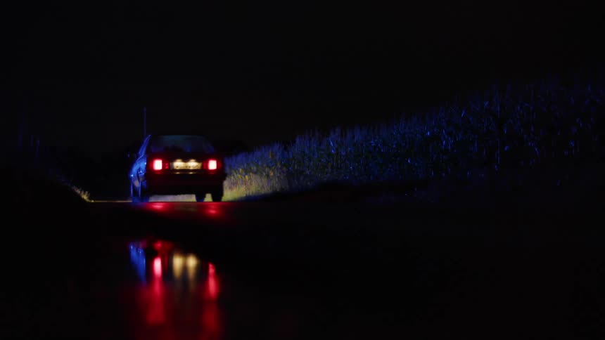 A car driving down a road at night
