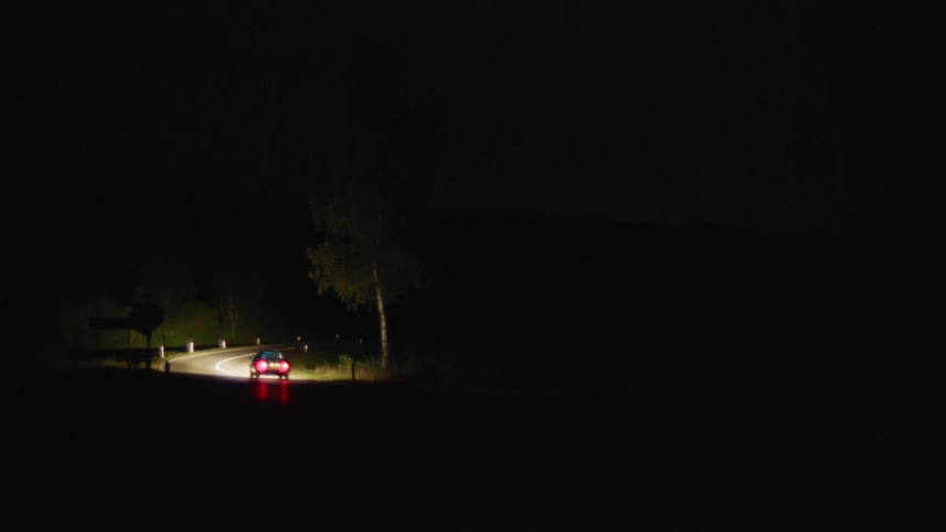 A car drives down a road at nighttime