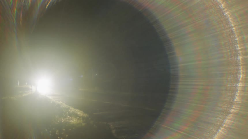 A car is driving down a road at night