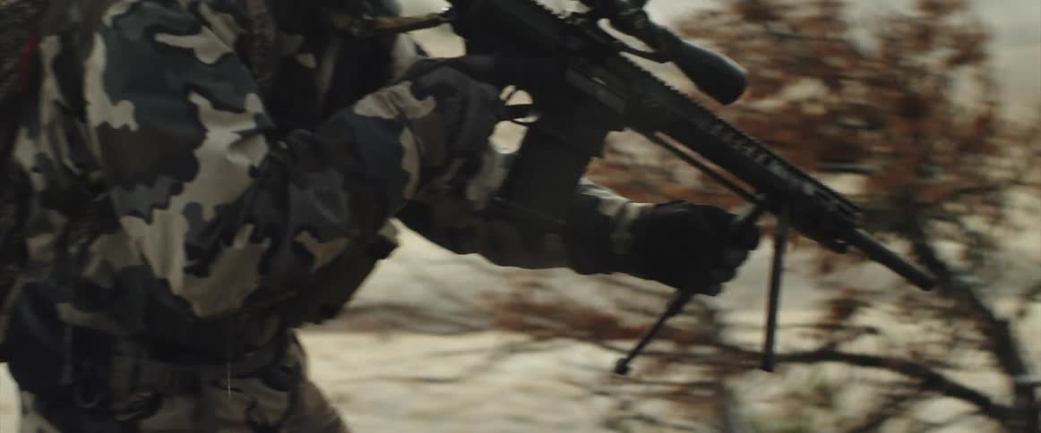 Man carrying rifle outdoors