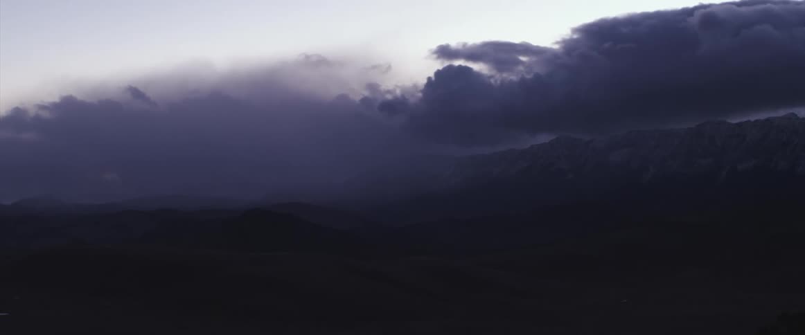 Dark clouds over the mountains at sunset