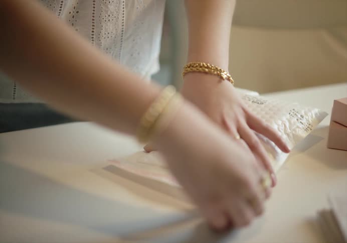Woman packing small boxes inside bubble wrap bags