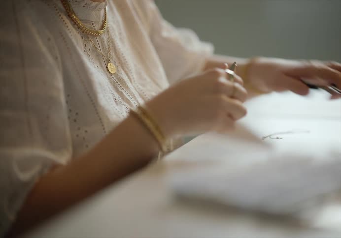 Woman sitting in a table hand crafting jewlery accessories