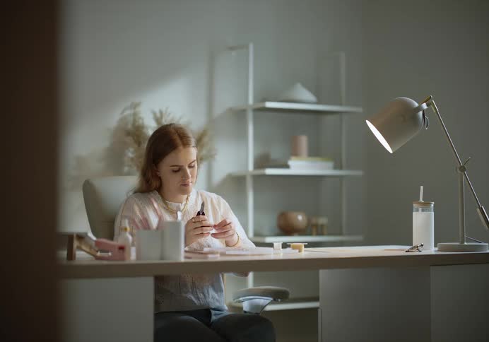 Woman sitting in a table hand crafting jewlery accessories