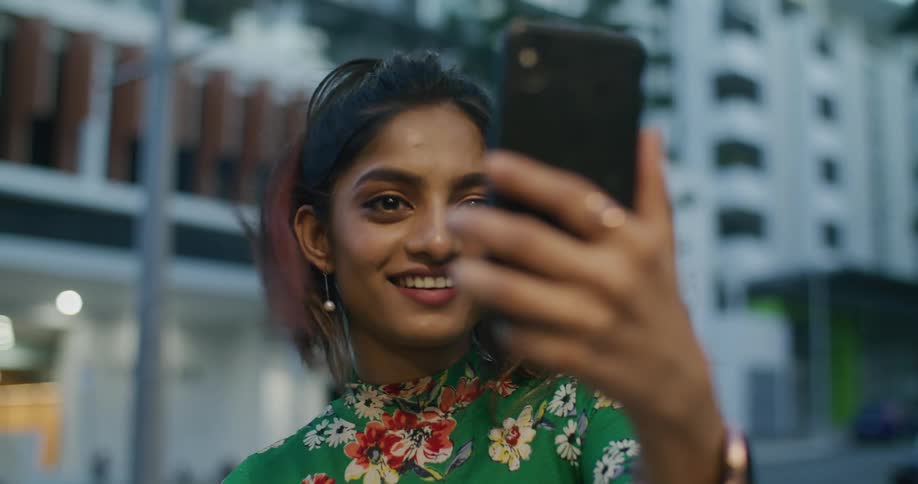 Young woman talking and laughing while talknig on a video call on her phone