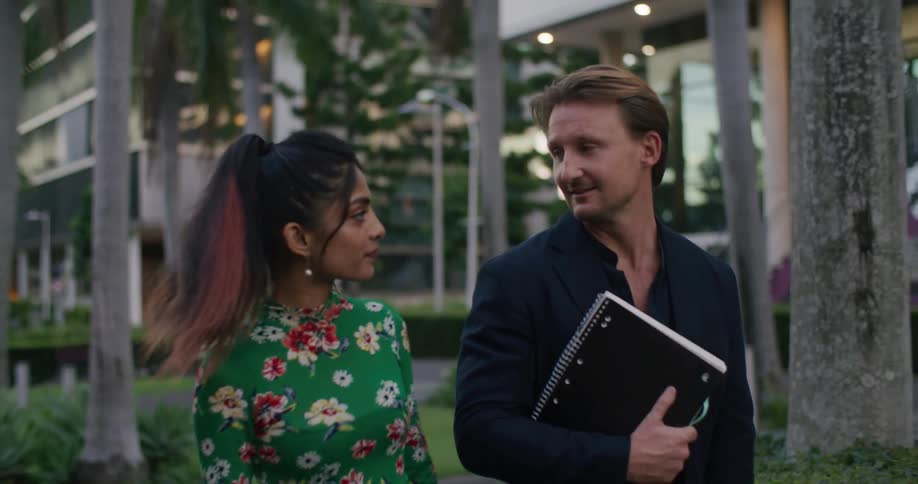 A man and woman walk and talk outside