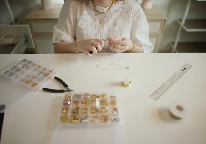 Woman sitting in a table hand crafting accessories