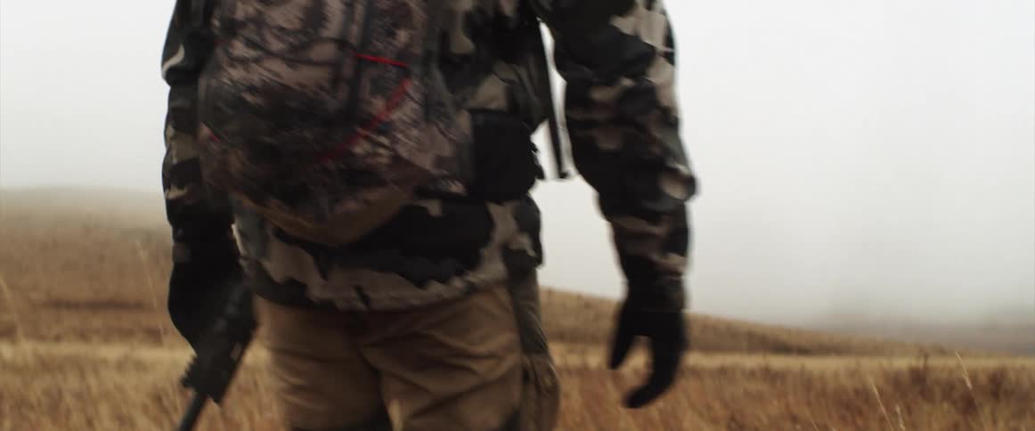 A hunter is carrying a deer head on his back