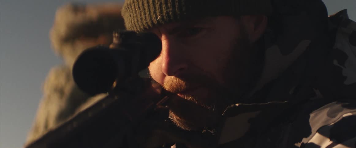 A man that is looking down a gun scope