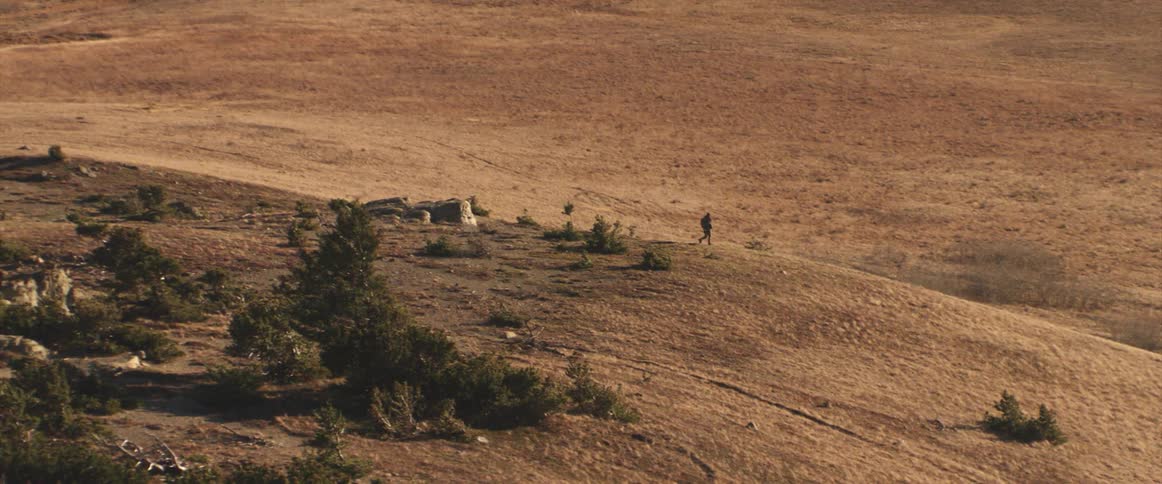 A man walking on the hills of a desert at daytime