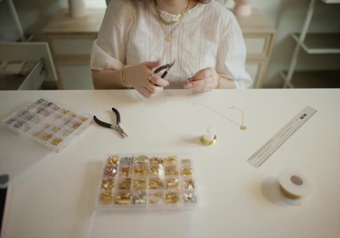 Woman sitting in a table hand crafting jewlery accessories
