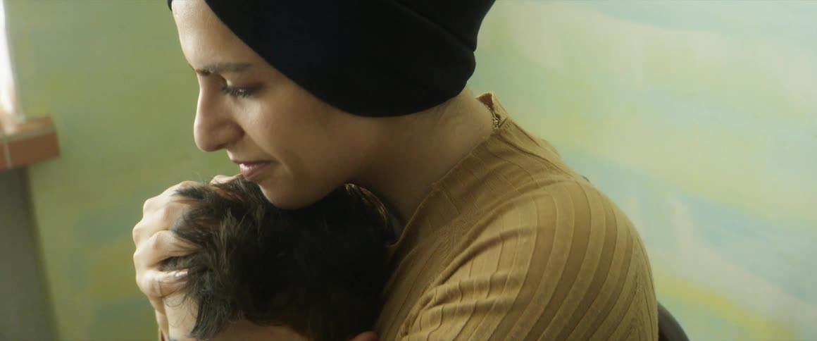 A mother holds her sleeping son in her lap