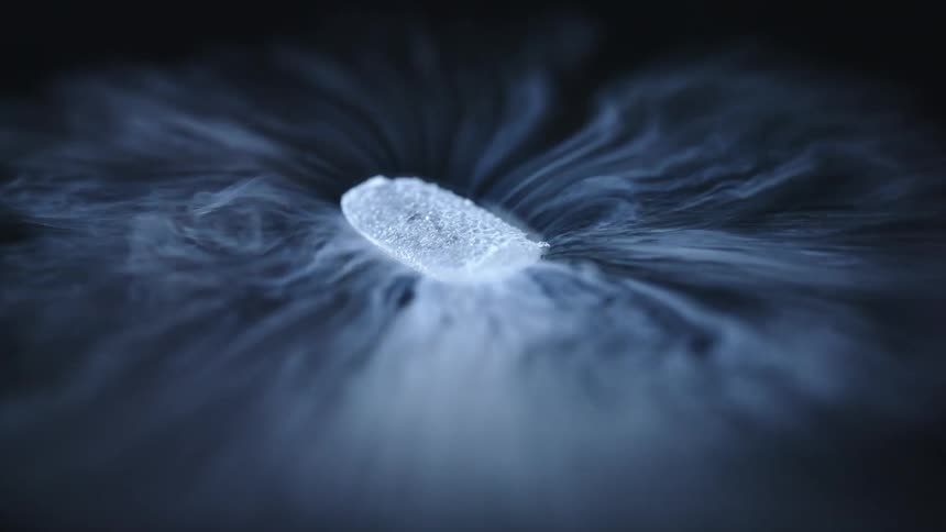 A single piece of dry ice slowly rotates while evaporating which creates a thin fog