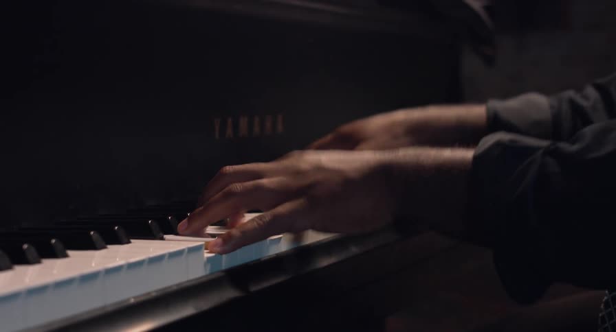 Person wearing long sleeve shirt plays piano rapidly