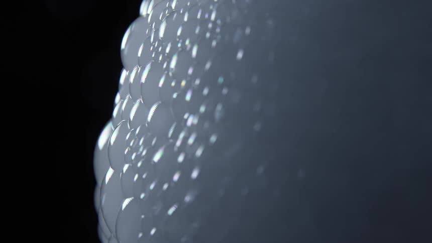 Wall of bubbles filled with white smoke on a dark room
