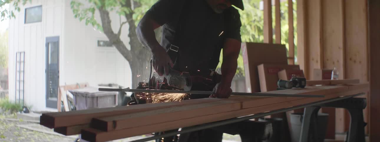 A man cutting metal with a saw