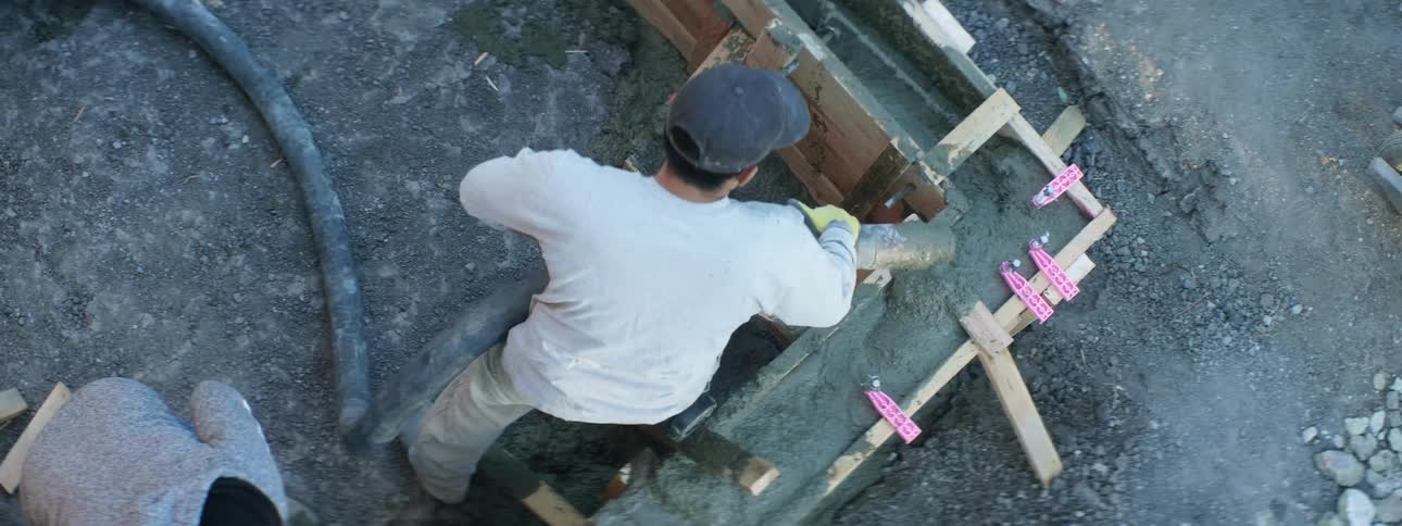 Two men are filling cement with a hose