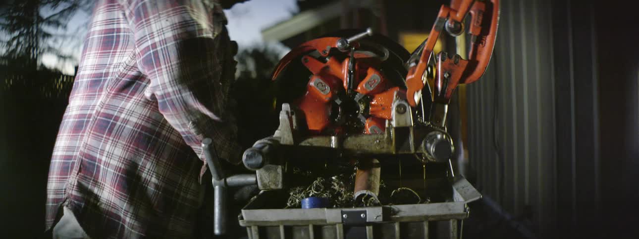 A man is using a machine in his yard