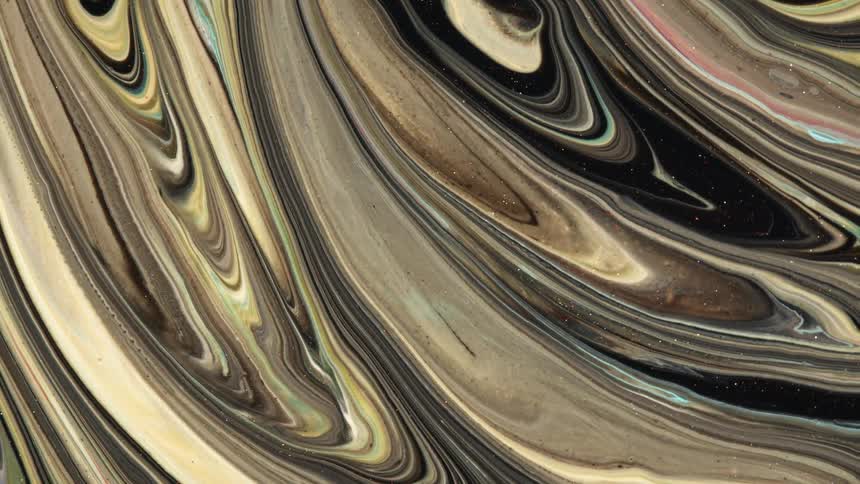 Swirls of brown and black sparkling liquid ink forms psychedelic abstract paterns