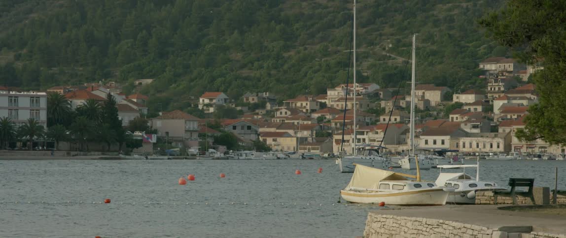 Buoys and boats float in the harbor of a mountain village