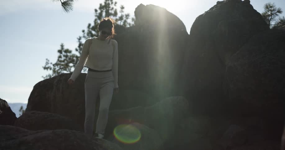 A woman hiking and jumping on rocks