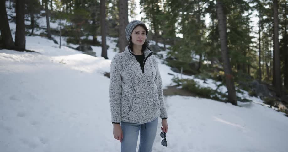 A woman is standing in the snow on the hill