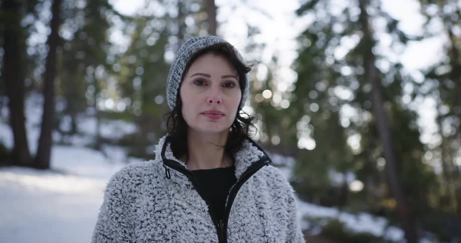 A woman standing in a forest with snow