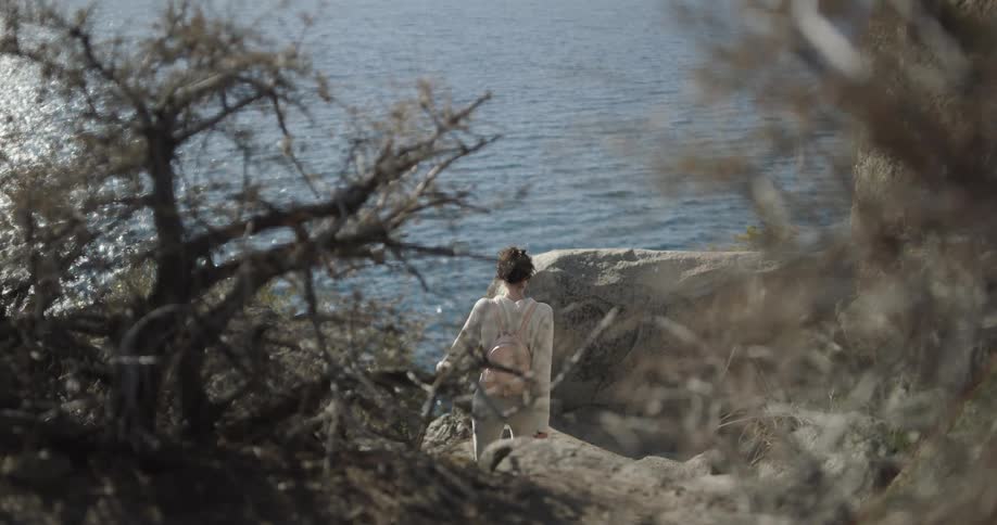 A woman is walking outdoors by the ocean