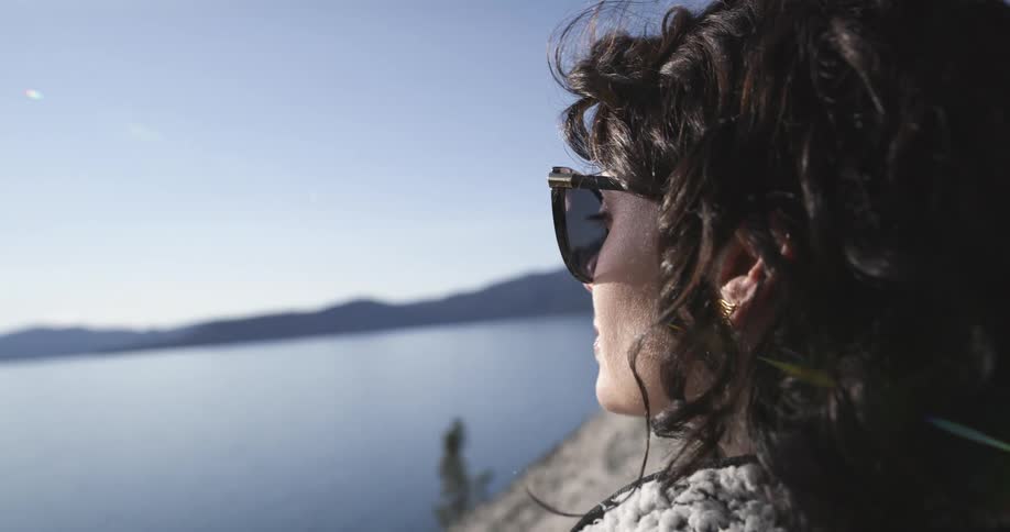 A woman is looking out over the water