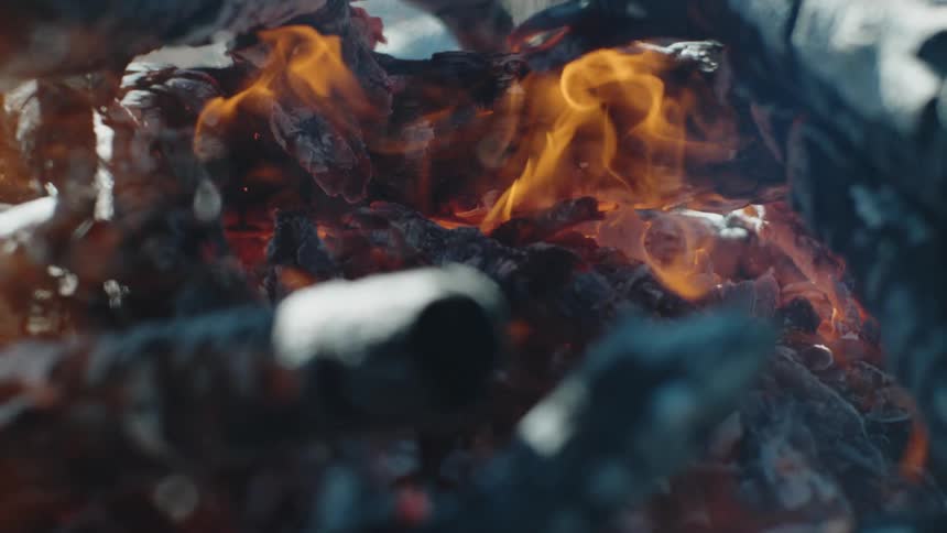 A fire burning with smoke ash and embers
