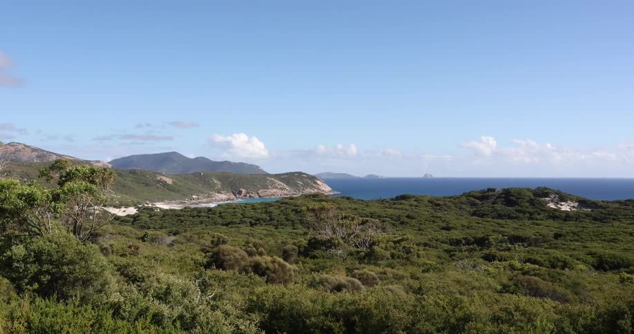 Clouds hover over mountains in background of inlet cutting into land