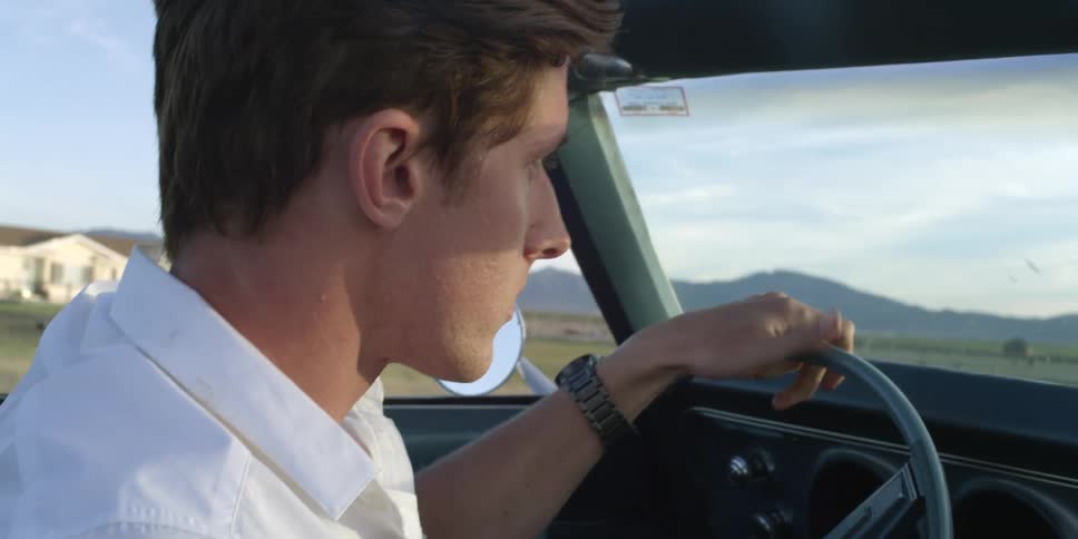 A man is driving a car during spring