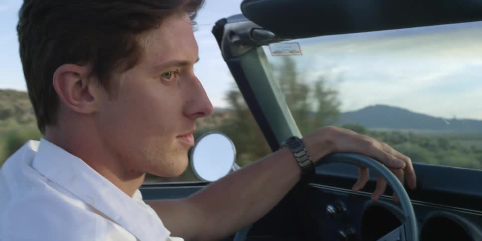 Young man drives an open top car
